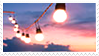 Stamp of light bulbs on a string against a sunset